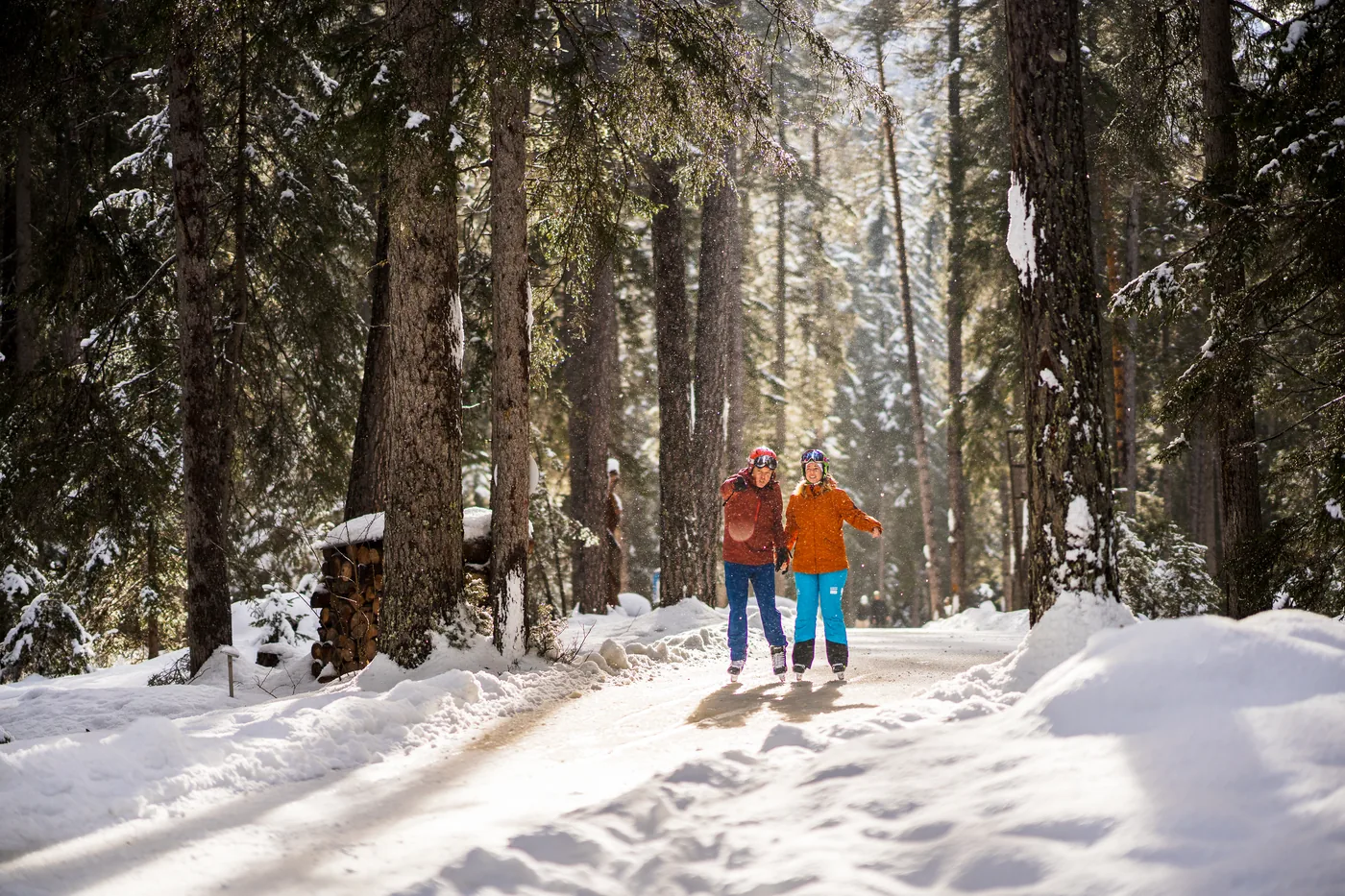 Twee schaatsers op het ijspad door het besneeuwde bos van Sur En.